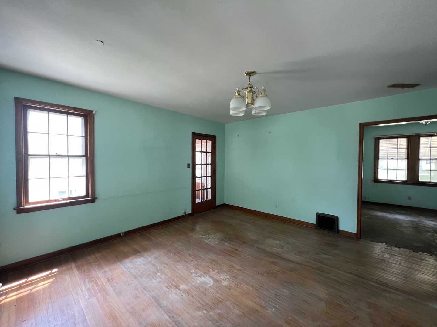 626 Woolf Court Rochelle, IL 61068 - Photo 3 of 23 an empty room with wooden floor chandelier and windows