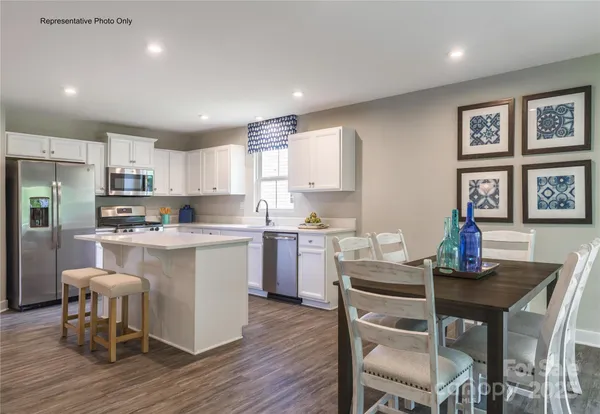 a kitchen with a dining table chairs refrigerator and cabinets