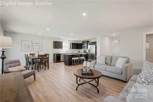 a living room with furniture and kitchen view