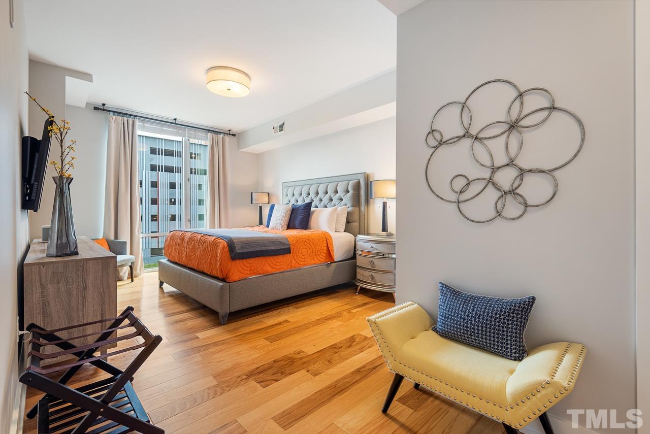 400 Hunt Street, Unit 406 Durham, NC 27701 - Photo 17 of 34 a bedroom with a bed and wooden floor