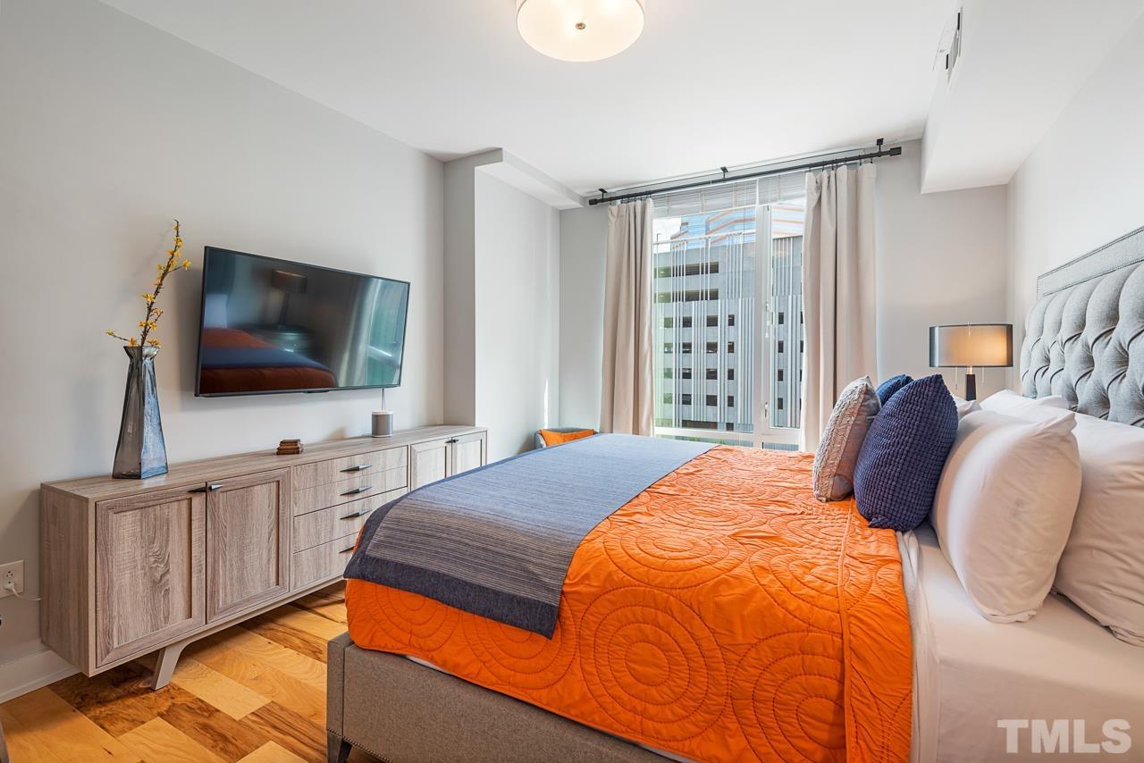 400 Hunt Street, Unit 406 Durham, NC 27701 - Photo 19 of 34 a bedroom with a bed and a flat screen tv