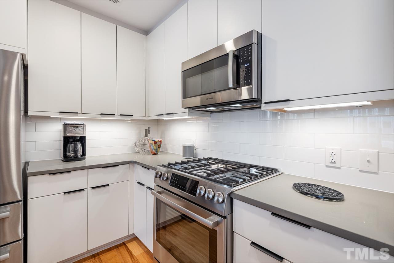 400 Hunt Street, Unit 406 Durham, NC 27701 - Photo 6 of 34 a kitchen with stainless steel appliances granite countertop a sink stove and microwave