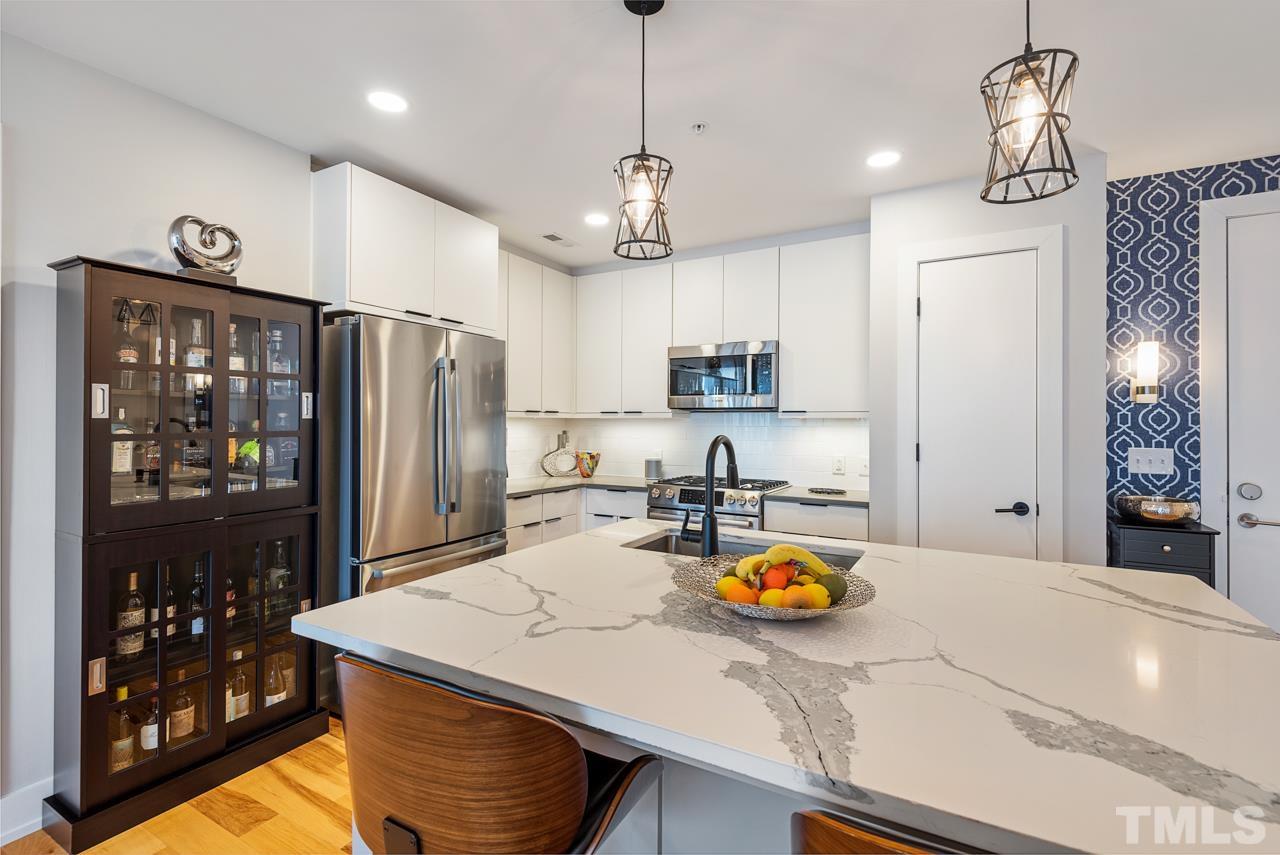 400 Hunt Street, Unit 406 Durham, NC 27701 - Photo 7 of 34 a kitchen with stainless steel appliances granite countertop a sink a refrigerator and a stove