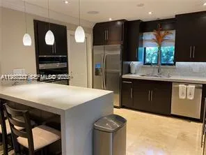 a kitchen with stainless steel appliances granite countertop a sink a stove and a refrigerator