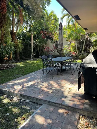 a view of a patio with table and chairs with wooden floor and fence