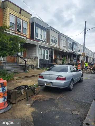 a front view of a building with cars parked