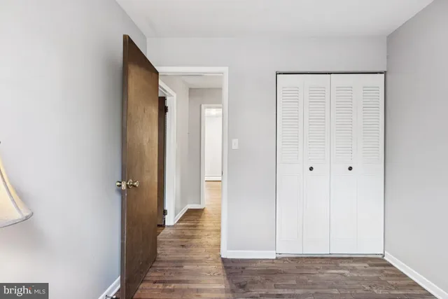 a view of a hallway with wooden floor and closet