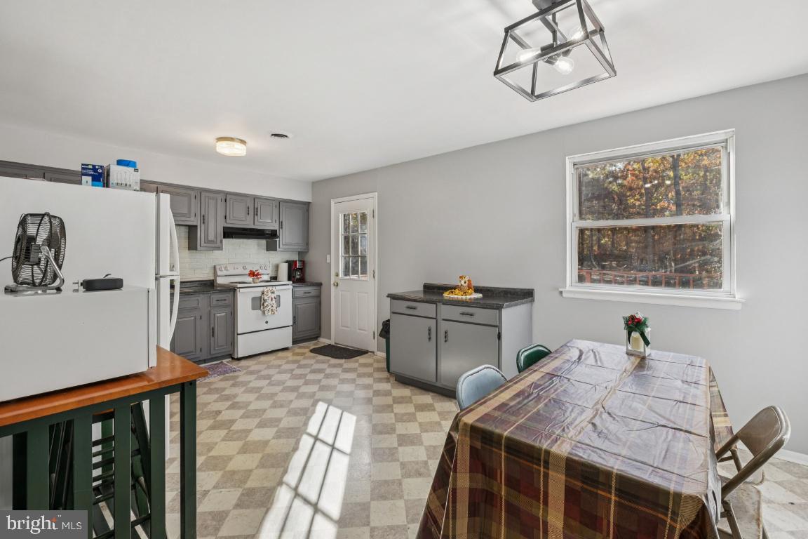 207 Sooy Place Road Tabernacle, NJ 08088 - Photo 6 of 25 a kitchen with stainless steel appliances kitchen island granite countertop a refrigerator a stove top oven a sink dishwasher and white cabinets with wooden floor