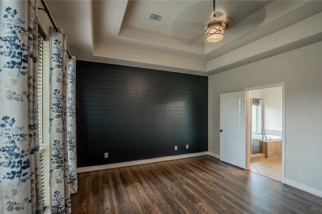 a en suite bathroom with a granite countertop sink and a mirror