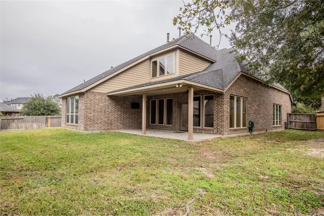 a view of a house with backyard and trees