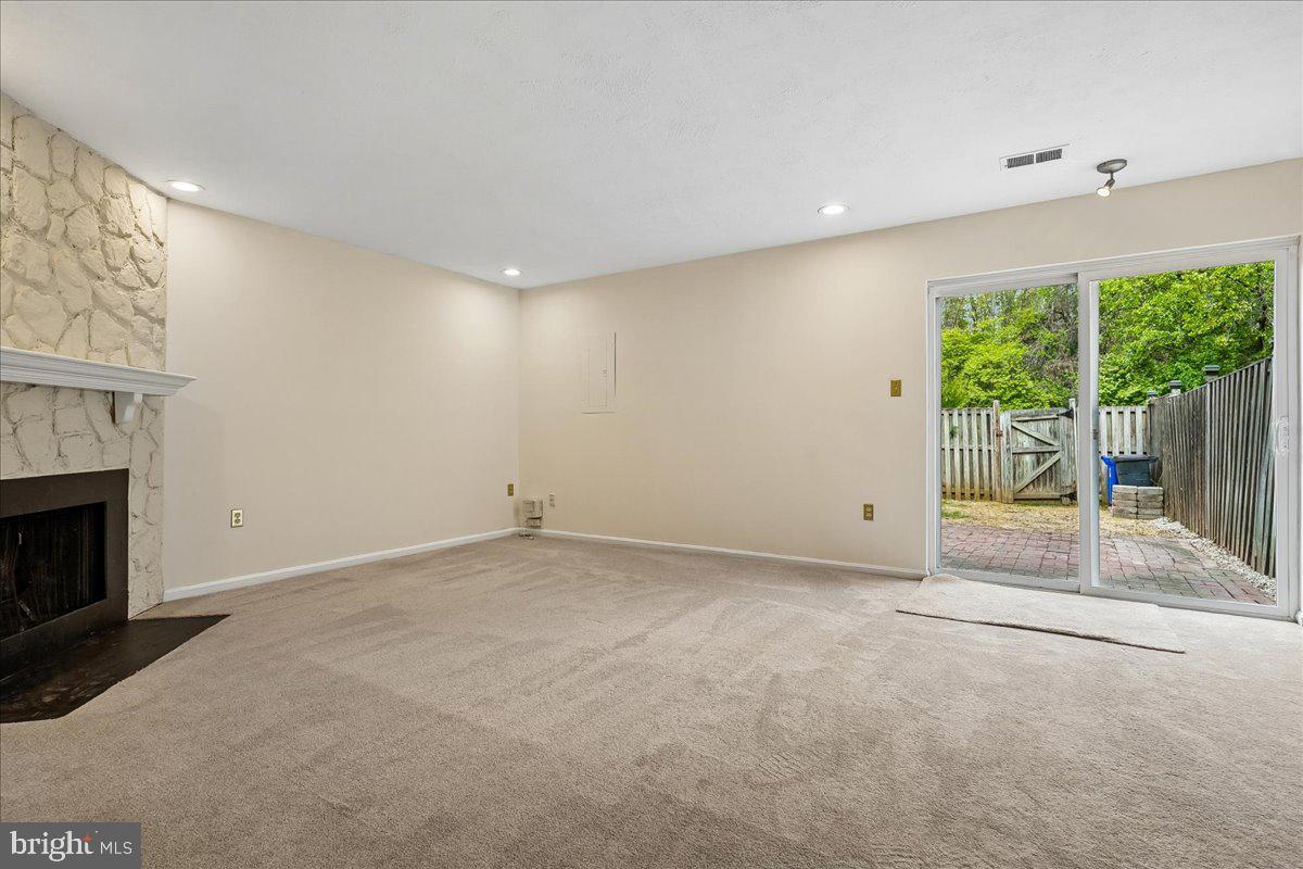 9752 High Water Court Burke, VA 22015 - Photo 17 of 25 a view of an empty room with wooden floor and a fireplace