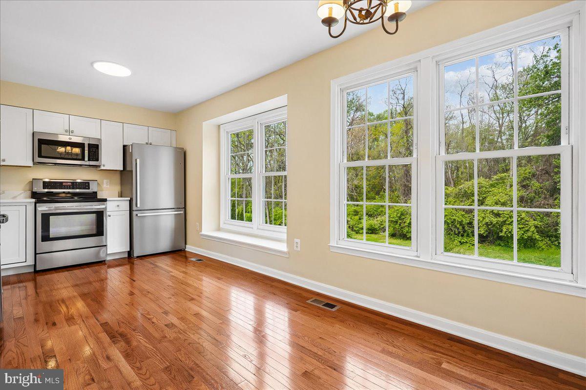 9752 High Water Court Burke, VA 22015 - Photo 5 of 25 a view of a kitchen with wooden floor electronic appliances and windows