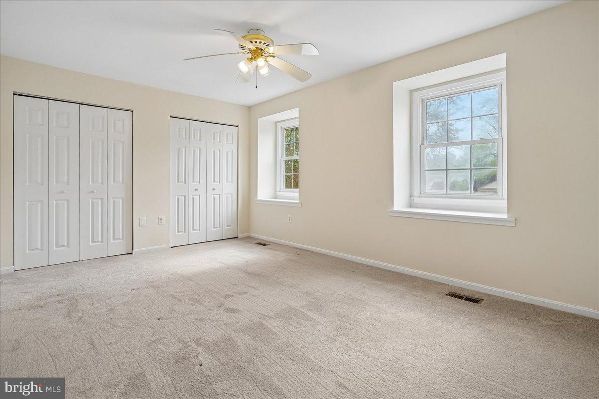 9752 High Water Court Burke, VA 22015 - Photo 9 of 25 an empty room with windows and chandelier fan