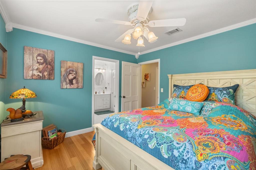 4345 Corley Island Road Leesburg, FL 34748 - Photo 13 of 73 a bedroom with a bed and a chandelier