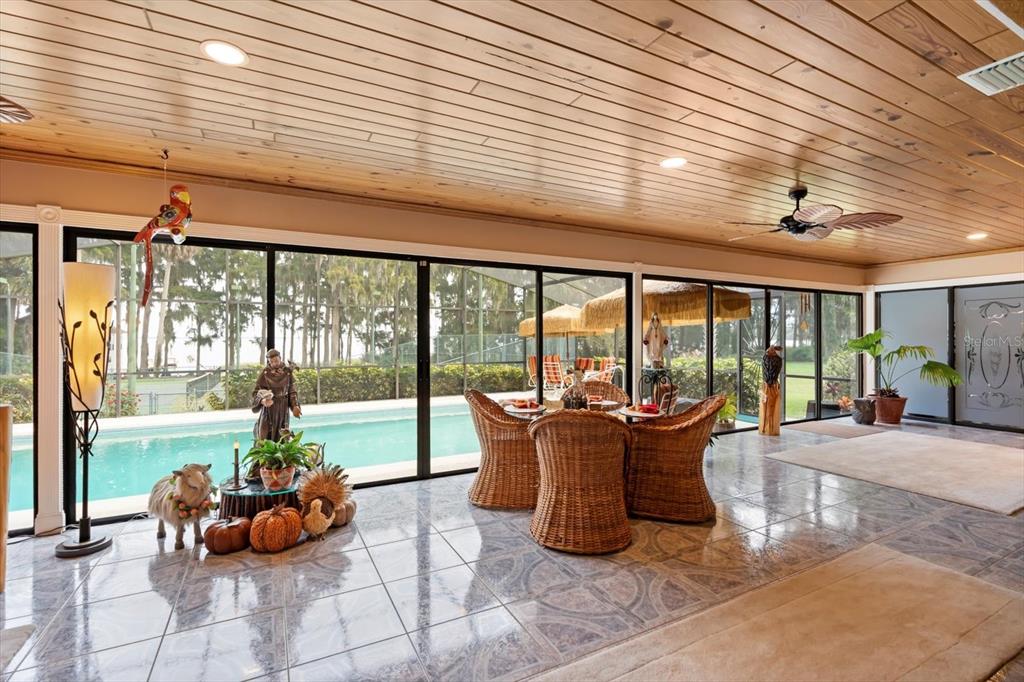 4345 Corley Island Road Leesburg, FL 34748 - Photo 25 of 73 a dining room with furniture and floor to ceiling windows