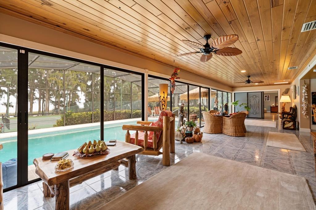 4345 Corley Island Road Leesburg, FL 34748 - Photo 26 of 73 a living room with furniture and a floor to ceiling window