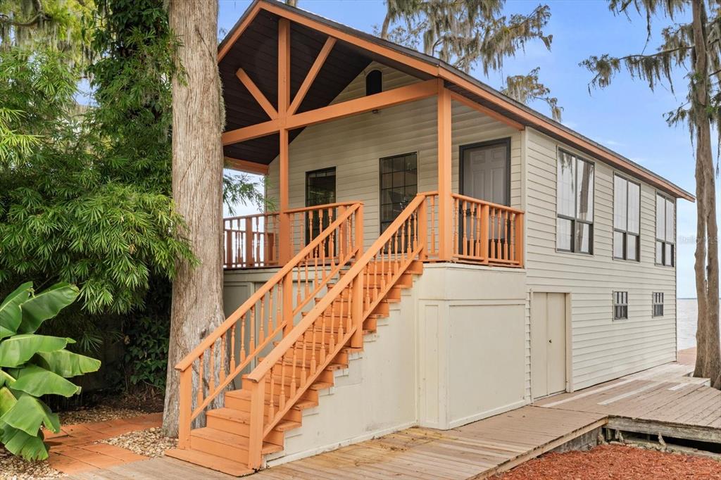 4345 Corley Island Road Leesburg, FL 34748 - Photo 45 of 73 a view of a house with wooden stairs and a small yard