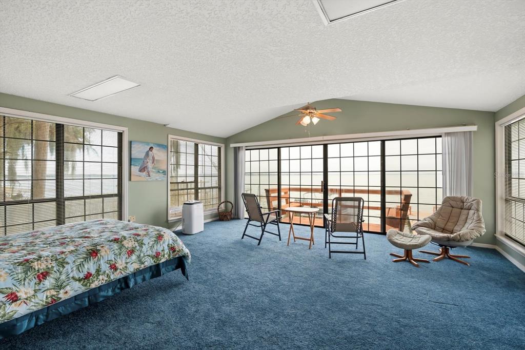 4345 Corley Island Road Leesburg, FL 34748 - Photo 47 of 73 a bedroom with a bed and large windows