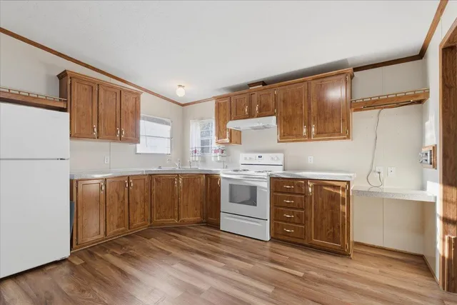 a kitchen with granite countertop a sink cabinets stainless steel appliances and a window