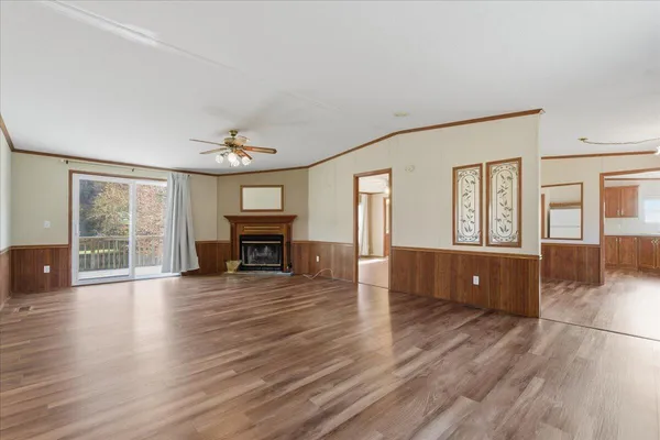 an empty room with wooden floor and fireplace