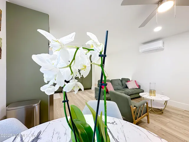 a living room with furniture kitchen view and a chandelier