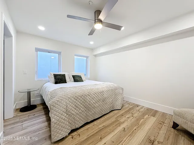 a bedroom with a bed and a ceiling fan