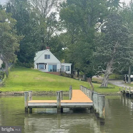 a small pool with lawn chairs and a yard