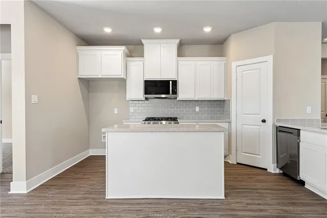 a view of kitchen with granite countertop cabinets and wooden floor