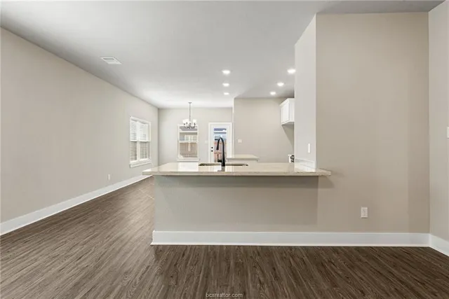 a view of a kitchen with wooden floor and windows