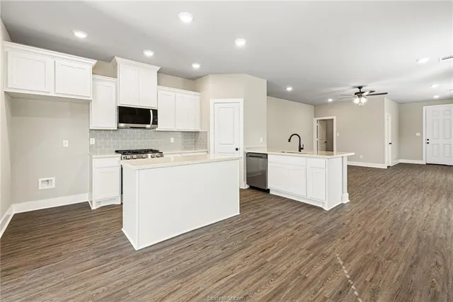 a kitchen with stainless steel appliances a refrigerator sink and cabinets