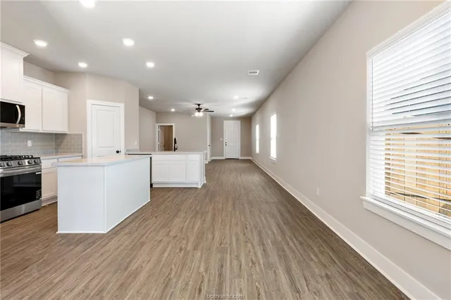 a view of a kitchen with a sink wooden cabinets and stainless steel appliances