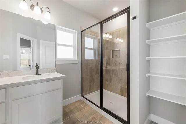 a bathroom with a shower sink and mirror