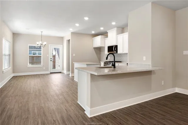 a view of a kitchen with a sink and wooden floor