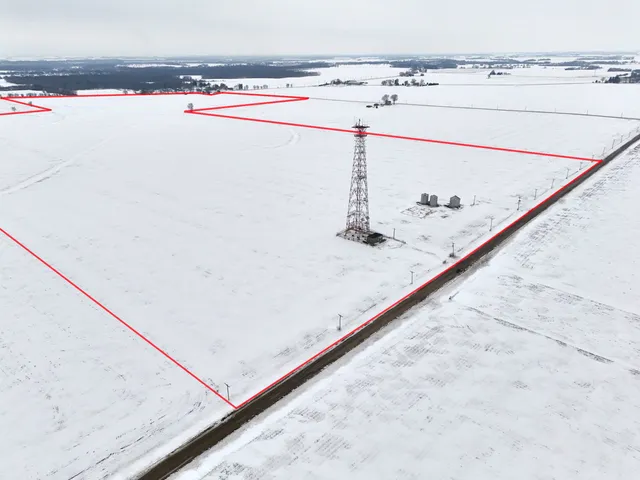 a bed with white sheets and pillows on it