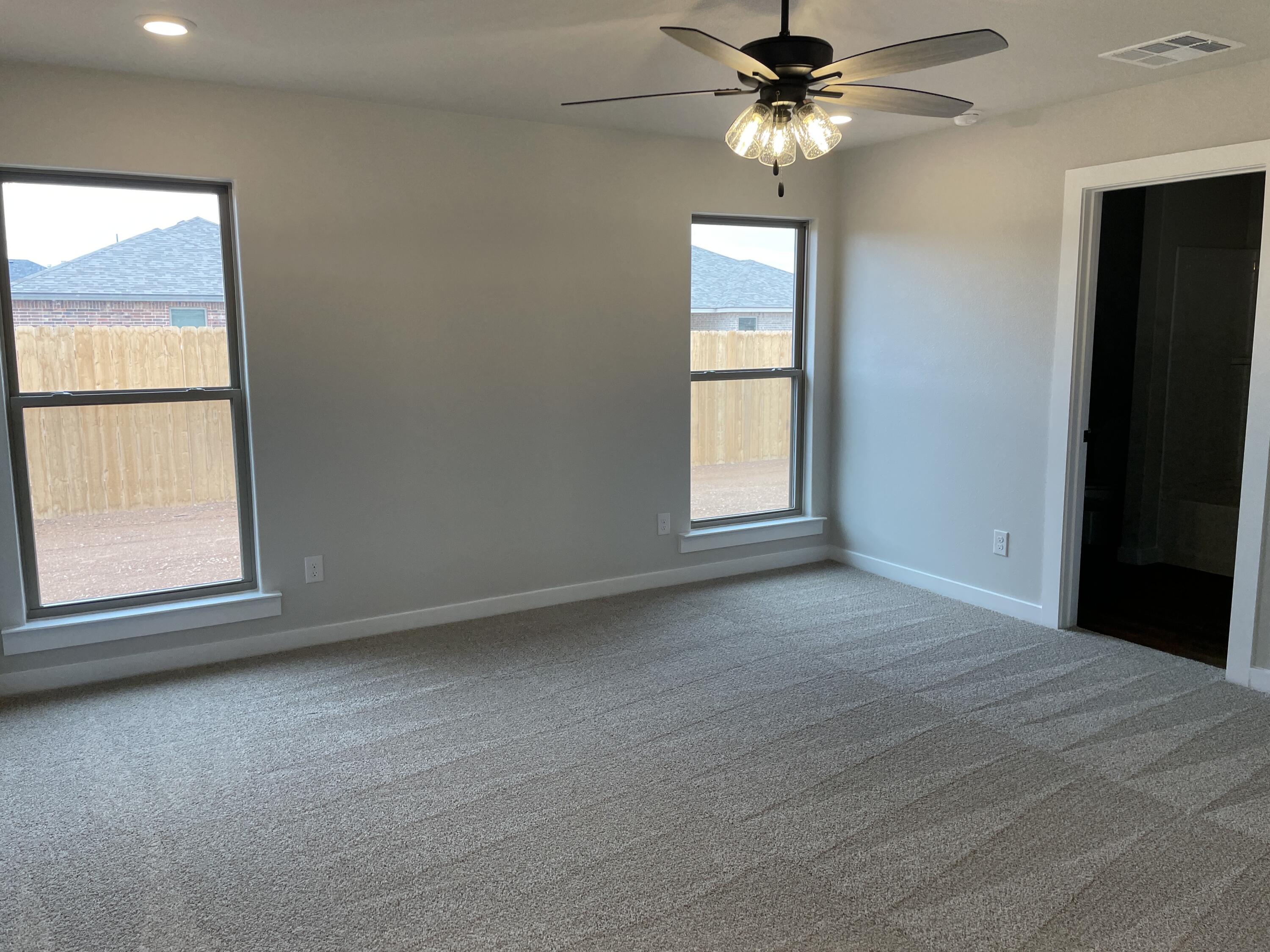 7450 29th Street Lubbock, TX 79407 - Photo 15 of 32 an empty room with windows and fan