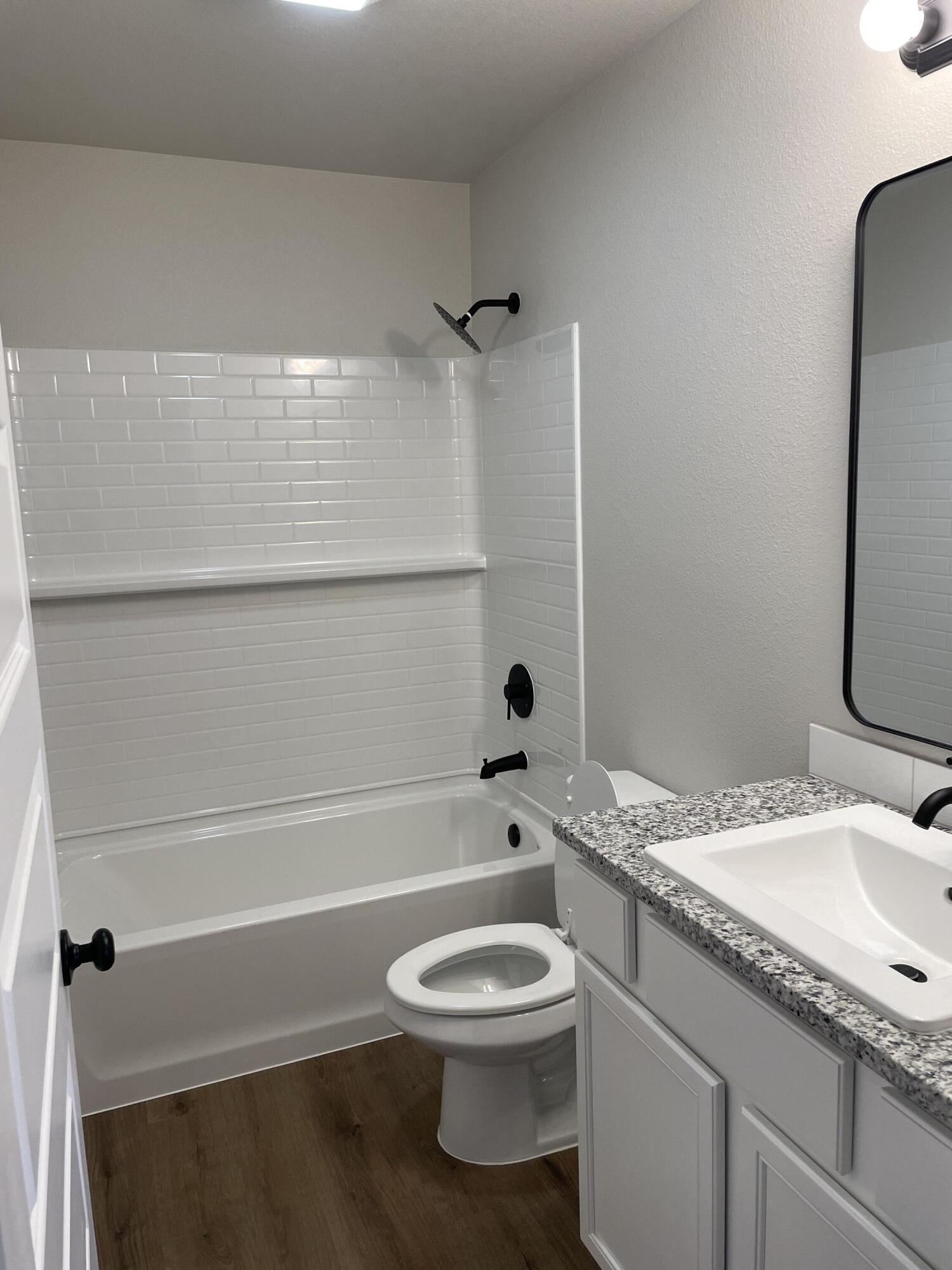 7450 29th Street Lubbock, TX 79407 - Photo 20 of 32 a bathroom with a granite countertop toilet sink and shower