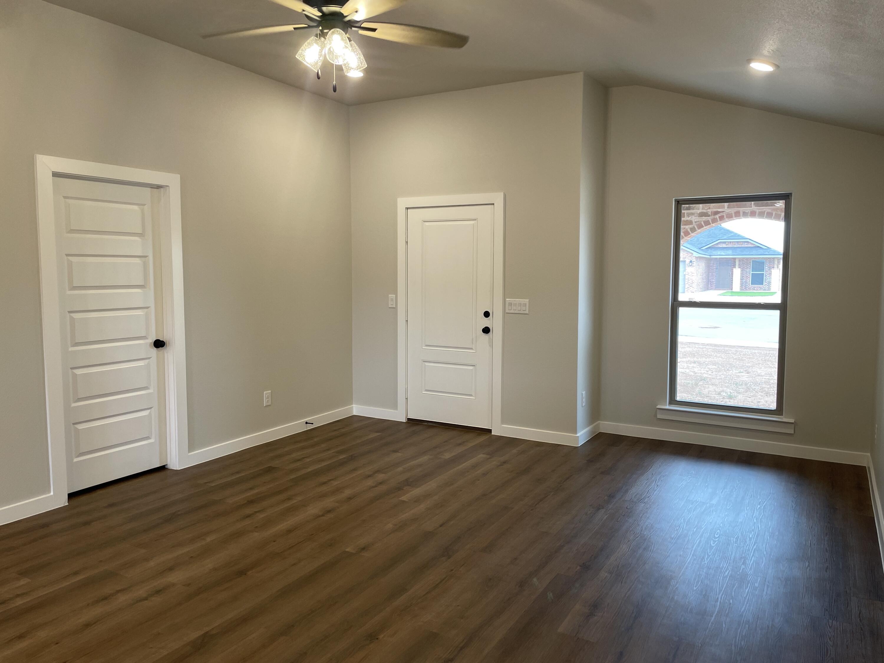 7450 29th Street Lubbock, TX 79407 - Photo 6 of 32 an empty room with wooden floor closet and windows