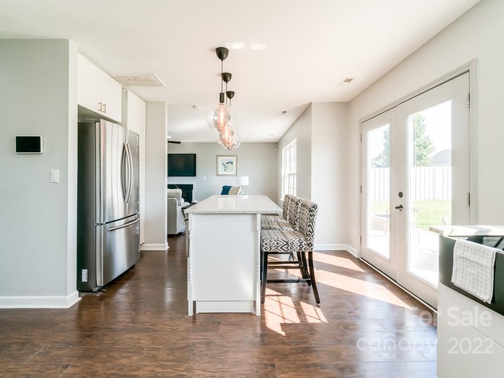 5510 Rogers Road Indian Trail, NC 28079 - Photo 12 of 35 a kitchen with stainless steel appliances a refrigerator a stove a sink dishwasher and a dining table with wooden floor