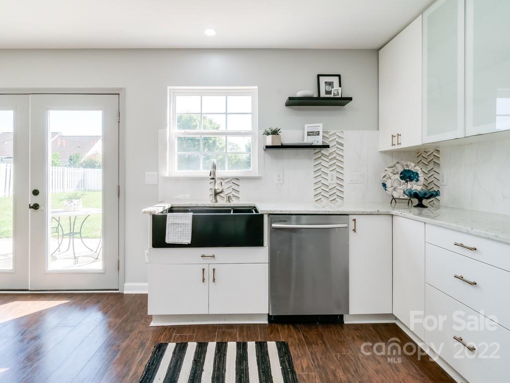 5510 Rogers Road Indian Trail, NC 28079 - Photo 16 of 35 a kitchen with stainless steel appliances a white cabinets and a wooden floor
