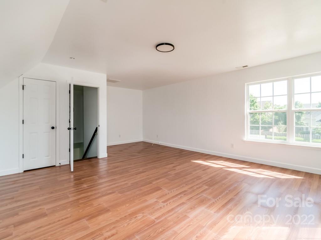 5510 Rogers Road Indian Trail, NC 28079 - Photo 18 of 35 an empty room with wooden floor and windows
