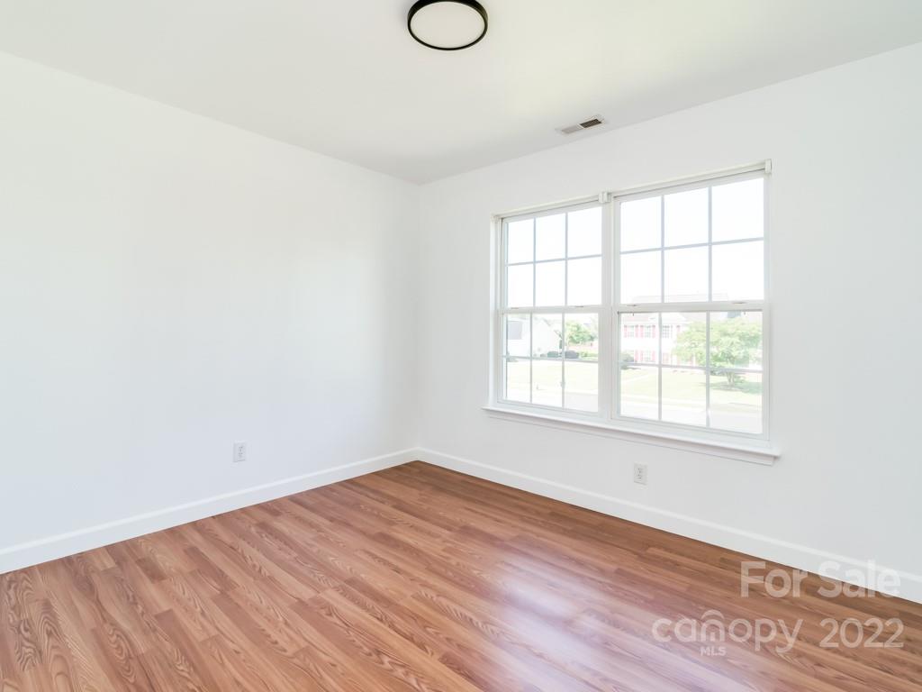 5510 Rogers Road Indian Trail, NC 28079 - Photo 27 of 35 an empty room with wooden floor and windows