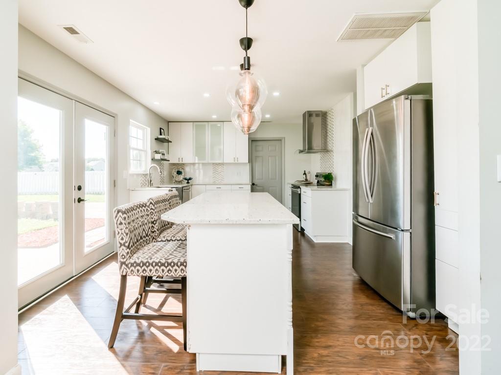 5510 Rogers Road Indian Trail, NC 28079 - Photo 10 of 35 a kitchen with stainless steel appliances granite countertop a refrigerator a microwave oven a sink with island and chairs
