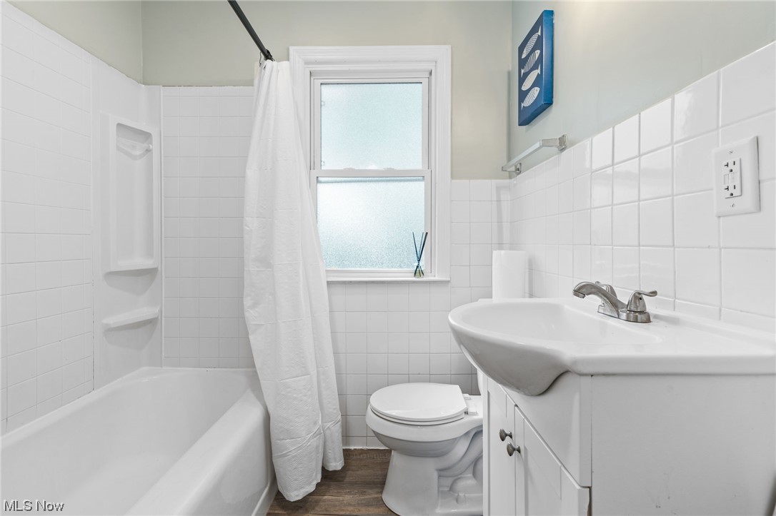 898 Reed Avenue Akron, OH 44306 - Photo 18 of 26 Full bathroom with vanity, wood-type flooring, tile walls, backsplash, and shower / bathtub combination with curtain