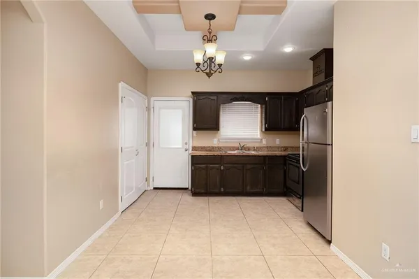 a large kitchen with a sink and refrigerator