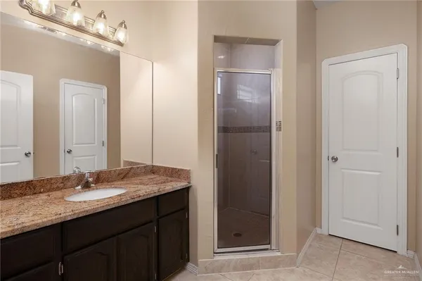 a bathroom with a granite countertop sink and a mirror