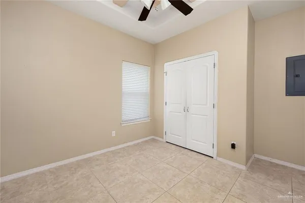 an empty room with chandelier fan