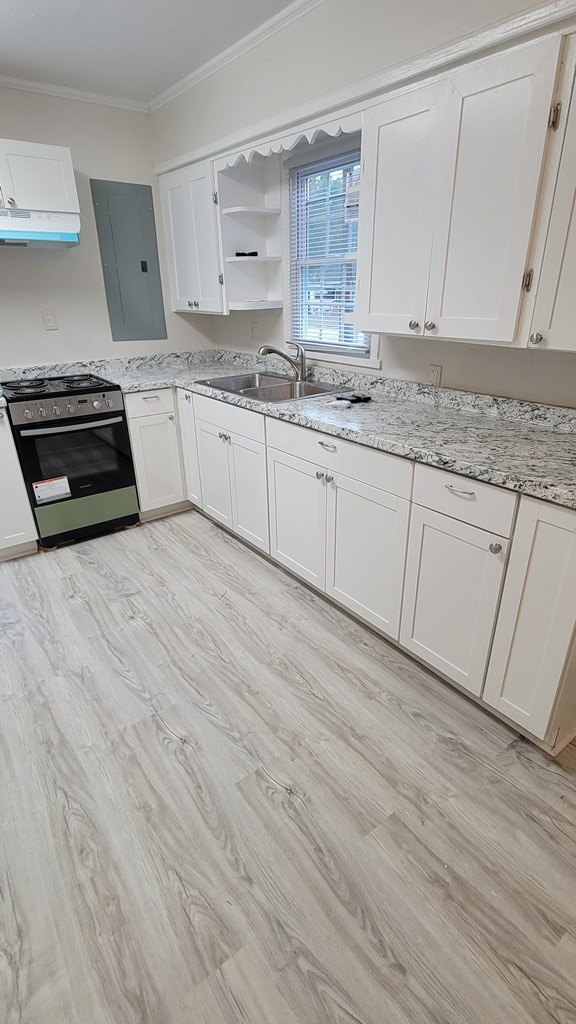 2502 Heard Street Columbus, GA 31906 - Photo 3 of 4 a kitchen with stainless steel appliances granite countertop a stove a sink and white cabinets