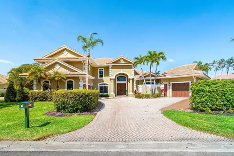 a front view of a house with a yard and potted plants