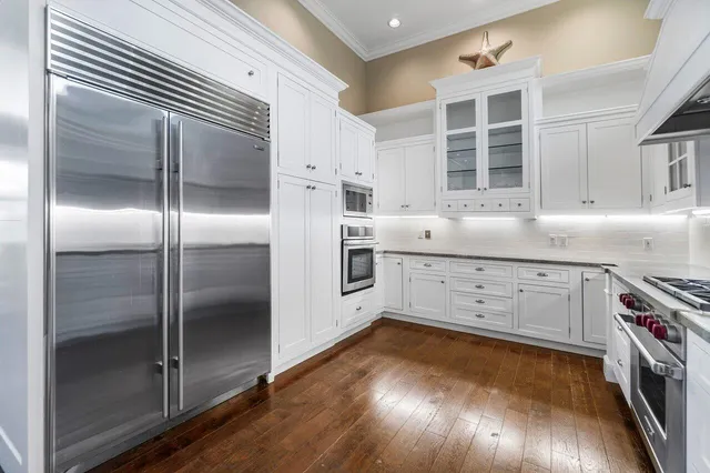 a kitchen with cabinets and wooden floor