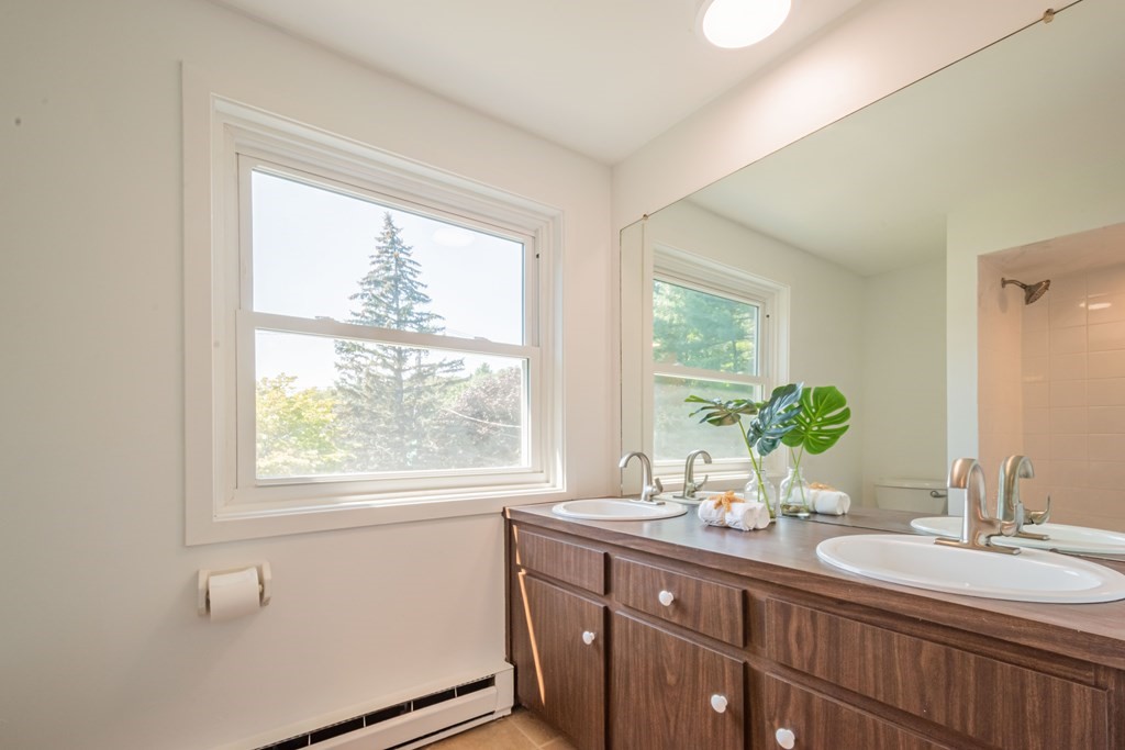 188 Spring Street Lexington, MA 02421 - Photo 32 of 42 a bathroom with a double vanity sink and large mirror